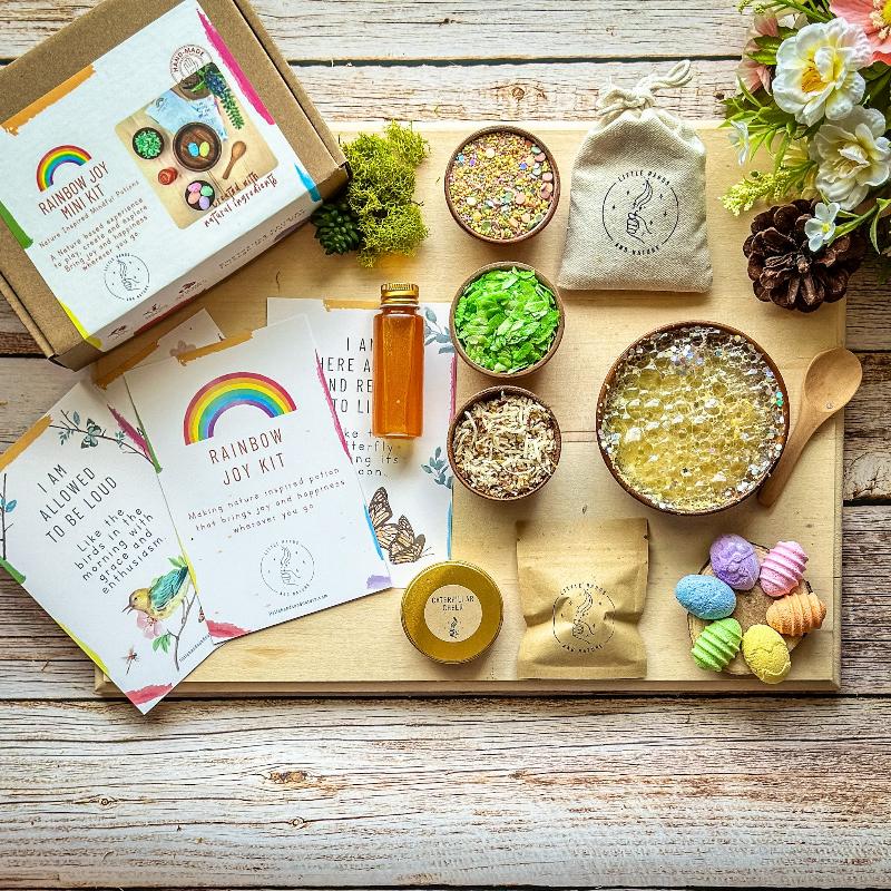 Colourful Rainbow Joy Potion Kit ingredients including Stardust Rainbow, Magic Eggs, Spring Leaves, Caterpillar Cheer, Liquid Carrot, and a wooden spoon.