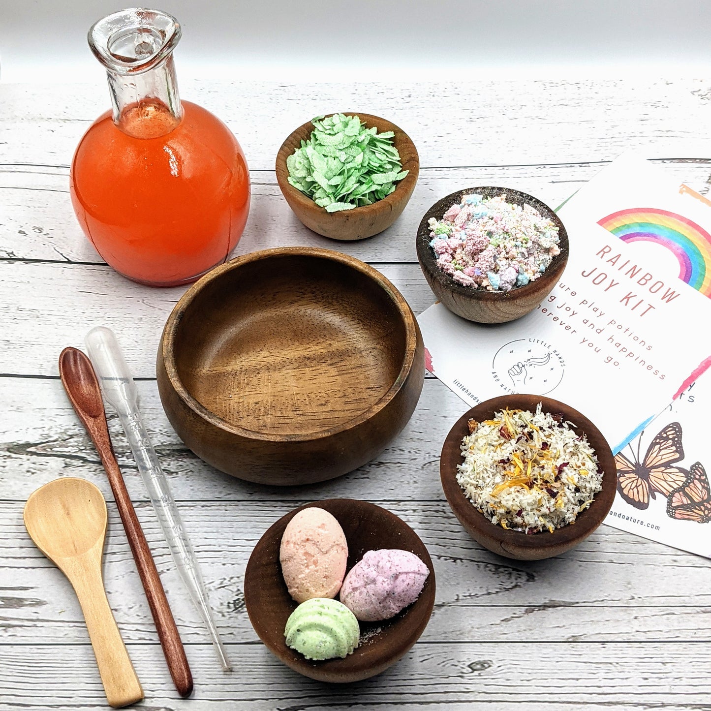 Colourful Rainbow Joy Potion making kit including variou ingredients - Stardust Rainbow, Magic Eggs, Spring Leaves, Caterpillar Cheer, Liquid Carrot, and a wooden spoon.